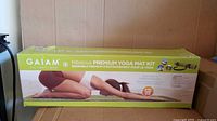Front of boxed Gaiam Hibiscus Premium Yoga Mat Kit showing product image