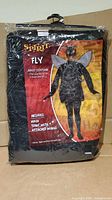 Front of sealed package displaying Spirit Halloween Fly costume graphic