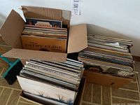 Two boxes filled with vinyl LPs, showing album spines and visible titles like The Patsy Cline Story