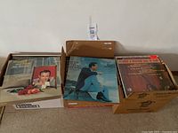 Three boxes of LP records; visible albums Jim Reeves, Eddie Fisher, Country & Western Hits in rear
