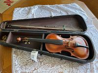 Violin, bow with missing hair, and case overall view