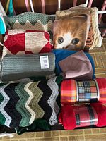 Collection of assorted blankets including quilt, crochet and fleece throws