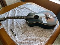 Full guitar on table showing body, neck and possible overall wear