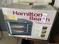 Factory-sealed Hamilton Beach 31197C countertop oven box showing product image and feature list