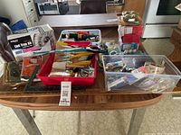 Wide view of table with assorted tools, hardware, lint trap kit, bins