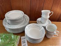 Assorted stacks of Somerset china showing plates, bowls, cups, mugs and green glass dish