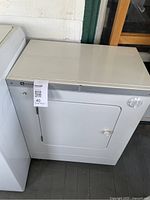 Front and top view of Maytag compact dryer next to larger appliance