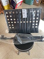 Music stand components still wrapped with chair seat visible