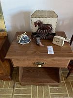 Overall view of nightstand top showing lamp, clocks, boot figurine