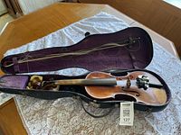 Violin in open case with bow and MaxSold tag