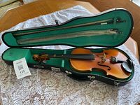 Violin inside open case with bows visible