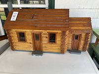 Front view of solid wood miniature log cabin house with extension, doors, windows and roof