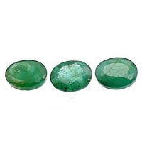 Three loose oval emerald gemstones displayed side by side