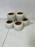 Five of the shrink-wrap rolls stacked, clear film visible