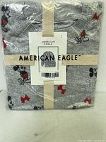 Front view of sealed pajama set showing print, ribbon, and branding