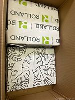 Top view showing two sealed Rolland reams and botanic-print wrapping on other ream