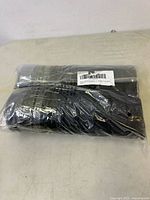 Plastic-wrapped bundle of black hockey pucks lying flat