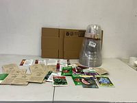 Full lot showing spread of seed packets and nested clear plastic pots