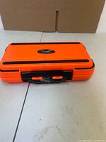 Closed orange tackle box front view showing brand label and latch