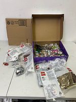 Overview of purple box and several sealed LEGO bags on table