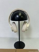 Front view of Monster cream wireless headphones on stand