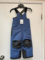 Front view of blue MEC Toaster Bib Pants hanging on hanger