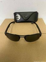 Front view of sunglasses with case behind