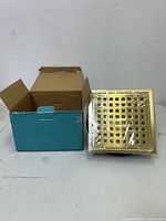 Box with Webang shower drain grate wrapped in plastic