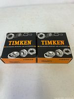 Front view of two sealed Timken bearing boxes showing branding and part numbers