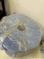 Top view of large blue cleaning cloth roll wrapped in clear plastic