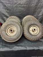 Front view showing six small pneumatic tires with steel hubs