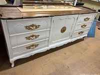 Full front view of dresser showing six drawers, central doors, white finish, dark top