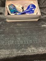 Pair of multicolor glass watering globes in box, angled view