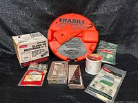 Full lot overview showing tip-up, Coleman globe box, mantles, line spool, tackle box, Tri-Pak