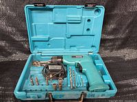Open case showing drill, bits, sockets in molded compartments