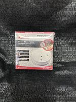 Front view of sealed Kidde Pro Series smoke alarm box