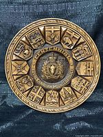 Front view of round RCMP Centennial carved plaque