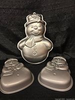 Front view showing one large and two small snowman pans