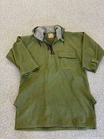 Full view of green wool bush shirt laid flat