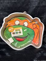 Front of shaped aluminum cake pan with colored paper insert