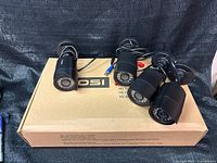 Four black Zosi bullet cameras resting on system box