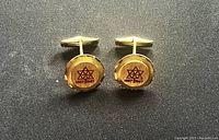 Front view of both cufflinks showing centennial emblems