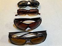 Four pairs sunglasses laid out vertically