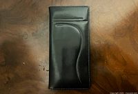 Front view of black leather wallet closed