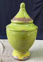 Front view of green glazed ceramic jar with lid