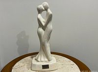 Front view of porcelain kissing couple sculpture showing iridescent finish and full form