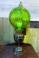 Full view of brass lamp with green globe shade