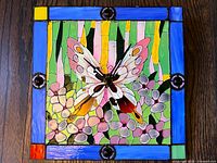 front view showing stained glass butterfly floral design and clock hands