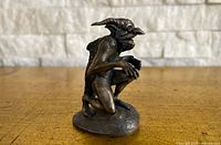 Front-left view of pewter demon figurine showing horns, crouched posture, base