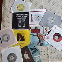 Overhead view showing all ten 45 RPM records in their sleeves